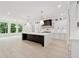 Bright kitchen with a large island, stainless steel appliances, black hardware, and large windows overlooking green space at 2977 N Bogan Rd, Buford, GA 30519