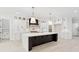 This bright kitchen boasts an oversized island with dark cabinetry, custom white cabinets, and stainless steel appliances at 2977 N Bogan Rd, Buford, GA 30519