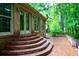 Classic brick patio with stairs leading to a brick house, surrounded by lush green trees at 5346 Light Cir, Norcross, GA 30071