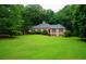 Expansive green lawn leading up to a single-story brick home with lush landscaping and mature trees at 5346 Light Cir, Norcross, GA 30071