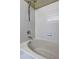 White tiled shower and tub combination featuring updated showerhead fixture at 10900 Wittenridge Dr # L6, Alpharetta, GA 30022
