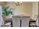 Cozy dining area illuminated by a chandelier with a view of lush greenery through a sliding glass door at 10900 Wittenridge Dr # L6, Alpharetta, GA 30022