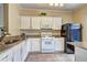 Well-lit kitchen boasts granite countertops, white cabinets, and stainless appliances at 10900 Wittenridge Dr # L6, Alpharetta, GA 30022
