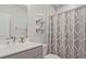 Neutral toned bathroom showcasing floating shelves above the toilet and a patterned shower curtain at 1149 Ansel Nw Ln, Atlanta, GA 30318