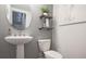 Stylish half bathroom with a pedestal sink, modern fixtures, shelving and a decorative mirror, creating a functional space at 1149 Ansel Nw Ln, Atlanta, GA 30318
