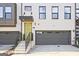 Townhome featuring a yellow front door, stone staircase, and an attached garage at 1149 Ansel Nw Ln, Atlanta, GA 30318