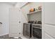 This laundry room features stainless steel washer and dryer with shelving for storage at 1149 Ansel Nw Ln, Atlanta, GA 30318