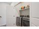 Convenient laundry room with stainless steel washer and dryer, and storage shelf above at 1149 Ansel Nw Ln, Atlanta, GA 30318