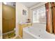 Bathroom with tub, toilet, shower, window, and a marble counter top at 120 Aspen Forest Dr, Covington, GA 30016