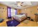 Bedroom with wood floors, ceiling fan, windows, decorative wall art, and a pink colored bed at 120 Aspen Forest Dr, Covington, GA 30016