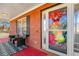 Inviting front porch with red painted floor and brick walls with black seating and festive decorations on the front door at 120 Aspen Forest Dr, Covington, GA 30016