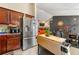 Modern kitchen seamlessly connected to the dining area, equipped with stainless steel appliances and dark wooden cabinets at 120 Aspen Forest Dr, Covington, GA 30016