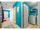 Laundry room featuring blue walls, tile floors, washer and dryer and access to other rooms at 120 Aspen Forest Dr, Covington, GA 30016