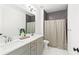Modern bathroom with double vanity, decorative mirror, tiled shower, and gray accents at 259 Sisson Ne Ave, Atlanta, GA 30317