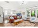 Bright living room featuring hardwood floors, a leather sofa, and large windows overlooking the front yard at 259 Sisson Ne Ave, Atlanta, GA 30317