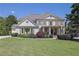 Elegant two-story home featuring a manicured lawn and welcoming covered front porch at 3735 Duckcove Way, Cumming, GA 30041
