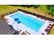 Aerial view of the community pool with lounge chairs and a splash umbrella at 5430 Flat Rock Pt, Stonecrest, GA 30038
