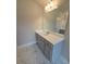 Bright bathroom with marble-look tile flooring featuring a grey vanity with a white countertop and a large mirror at 1107 Kingston Hill Dr, Loganville, GA 30052