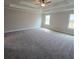 Large carpeted bedroom featuring a tray ceiling, ceiling fan, and abundant natural light from double windows at 1107 Kingston Hill Dr, Loganville, GA 30052