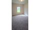 Cozy bedroom with plush carpet, a window, and neutral walls at 1107 Kingston Hill Dr, Loganville, GA 30052