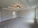 Expansive bedroom with a tray ceiling, ceiling fan, and plush carpeting for ultimate comfort and style at 1107 Kingston Hill Dr, Loganville, GA 30052