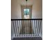 Foyer view overlooking staircase with decorative wrought iron railing and elegant light fixture at 1107 Kingston Hill Dr, Loganville, GA 30052