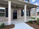 Inviting front porch with classic black door, white columns, and elegant exterior lighting at 1107 Kingston Hill Dr, Loganville, GA 30052