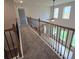 Upstairs hallway boasts decorative iron railings and trim, overlooking the floor below and brightened by natural light at 1107 Kingston Hill Dr, Loganville, GA 30052