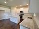 Bright kitchen with white cabinets, island, granite countertops, and stainless steel appliances at 1107 Kingston Hill Dr, Loganville, GA 30052