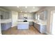 Modern kitchen featuring gray cabinets, stainless steel appliances, an island, and quartz countertops at 1107 Kingston Hill Dr, Loganville, GA 30052
