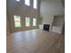 Living room featuring a fireplace, built-in shelves, large windows, and light hardwood floors at 1107 Kingston Hill Dr, Loganville, GA 30052