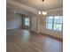 Open living room with hardwood floors, large windows, and elegant chandelier at 1107 Kingston Hill Dr, Loganville, GA 30052