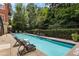 Community outdoor pool with inviting lounge chairs, mature trees, and secure gated access for resident relaxation at 560 Dutch Vly # 2313, Atlanta, GA 30324