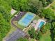 Aerial view of community amenities including a tennis court, playground, swimming pool, and parking, surrounded by mature trees at 6520 Glen Pond Trce, Cumming, GA 30028