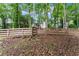Backyard featuring a partial fence offering privacy, backing up to mature trees, and a well-maintained lawn at 6520 Glen Pond Trce, Cumming, GA 30028
