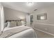 Bright bedroom featuring a comfortable bed, a night stand, and a mirror at 6520 Glen Pond Trce, Cumming, GA 30028