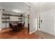 Dining room with a round table, adjacent bar area with liquor shelves, and a bright entryway with a white front door at 6520 Glen Pond Trce, Cumming, GA 30028