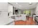 Beautiful kitchen boasts white cabinetry, stainless steel appliances, and a farmhouse sink at 6520 Glen Pond Trce, Cumming, GA 30028