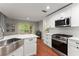 Bright kitchen showcases white cabinets, stainless steel appliances, and a view of the backyard at 6520 Glen Pond Trce, Cumming, GA 30028