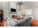 Bright, airy living room with hardwood floors, fireplace, tall windows, and open access to the modern kitchen at 6520 Glen Pond Trce, Cumming, GA 30028