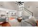 Open-concept living room with a staircase, a view into the modern kitchen, and gray furniture and hardwood flooring at 6520 Glen Pond Trce, Cumming, GA 30028