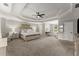 Spacious main bedroom features a tray ceiling, ceiling fan, sitting area, and neutral decor at 6520 Glen Pond Trce, Cumming, GA 30028