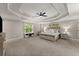 Spacious main bedroom with trey ceilings, a ceiling fan, neutral carpeting, and large windows with natural light at 6520 Glen Pond Trce, Cumming, GA 30028