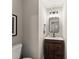 A charming powder room with a wood vanity, vessel sink, decorative mirror, modern lighting, and neutral wall color at 6520 Glen Pond Trce, Cumming, GA 30028