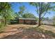 Expansive backyard with a brick house, covered patios, mature trees, and plenty of space for outdoor activities at 264 Rockin Hill Dr, Marietta, GA 30060
