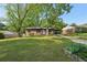 Charming single-story brick home with a lush green lawn and mature trees providing shade at 264 Rockin Hill Dr, Marietta, GA 30060