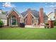 Expansive backyard features a brick house, green lawn, patio, outdoor dining, lounge chairs, and a built-in grill at 350 Declaire Ne Way, Marietta, GA 30067