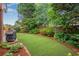 Well-maintained backyard with healthy grass, manicured landscaping, and privacy fencing create a serene outdoor space at 350 Declaire Ne Way, Marietta, GA 30067