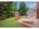 Beautiful backyard with manicured lawn, patio, brick wall, and mature trees for shade at 350 Declaire Ne Way, Marietta, GA 30067