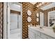 Bathroom features vintage wallpaper, white vanity with sink, mirror, and a tub with shower at 350 Declaire Ne Way, Marietta, GA 30067